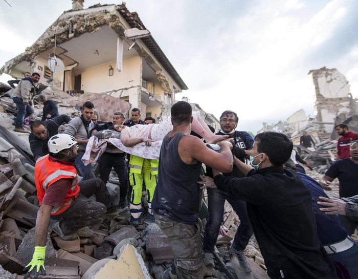 epa05603348 YEARENDER 2016 AUGUST  An injured woman (C) is carried by rescuers amid the rubble of collapsed buildings in Amatrice, central Italy, 24 August 2016, following a 6.2 magnitude earthquake, according to the United States Geological Survey (USGS), that struck at around 3:30 am local time (1:30 am GMT). The quake was felt across a broad section of central Italy, including the capital Rome where people in homes in the historic center felt a long swaying followed by aftershocks.  EPA/MASSIMO PERCOSSI