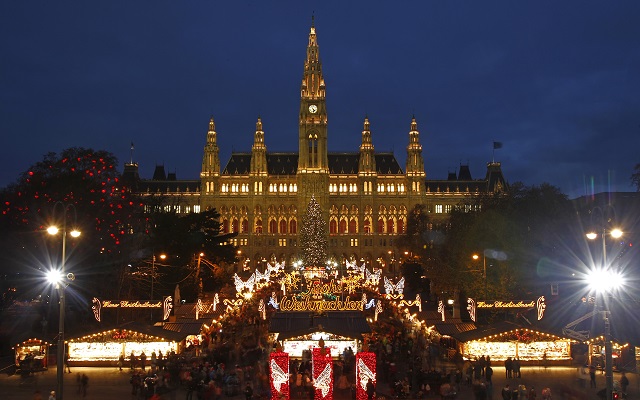 The city hall is pictured behind Christkindlmarkt advent market in Vienna November 29, 2013. The German expression "Es weihnachtet sehr" (It's getting very Christmassy) fits the mood in Vienna as Austria's capital decks itself out in style for the holiday season. The centre of the old Habsburg empire treats locals and visitors to quaint Christmas markets featuring crafts and decorations, hot punch and baked goods in all the city's main squares. Picture taken November 29, 2013. REUTERS/Heinz-Peter Bader  (AUSTRIA - Tags: SOCIETY TRAVEL) - RTX166PM