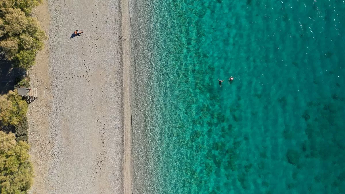 Αεροφωτογραφία από drone του όμορφου παραθαλάσσιου χωριού και της τιρκουάζ παραλίας του Πόρτο Γερμενό, στον Κορινθιακό κόλπο, στη Δυτική Αττική