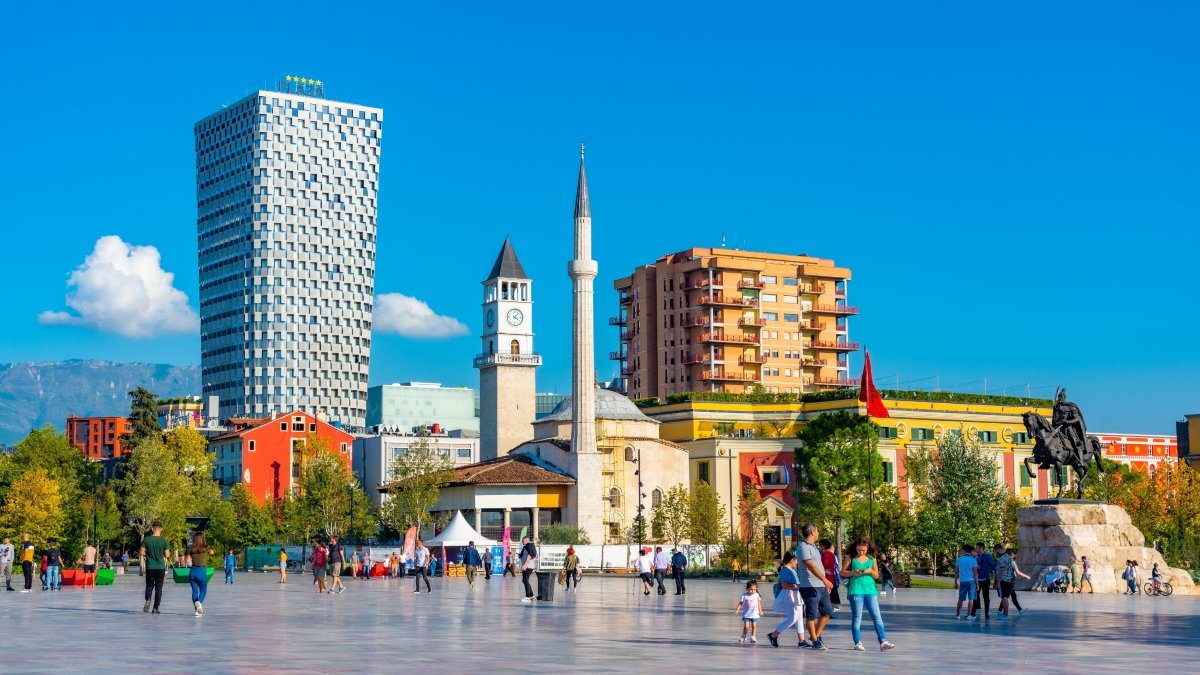 Άνθρωποι περπατούν μπροστά από το μνημείο Skanderbeg και το τζαμί Ethem Bey στα Τίρανα της Αλβανίας.